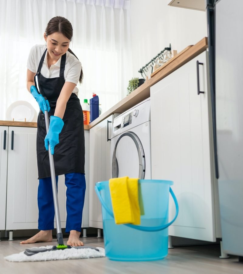 asian active cleaning service woman worker cleaning feel happy in kitchen at home